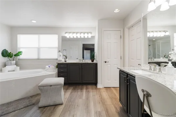 a large bathroom with a double vanity sink a mirror and a bathtub