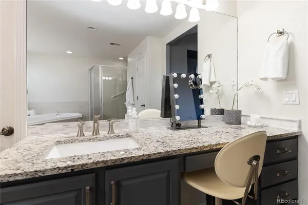 a bathroom with a granite countertop double vanity sink and a mirror