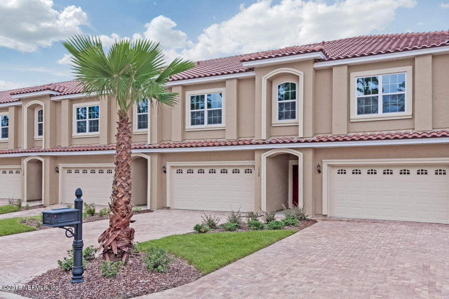 a front view of a house with a garden and yard
