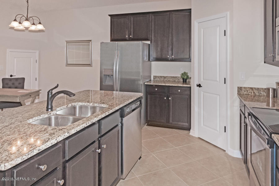 1708 Sanctuary Way Fleming Island, FL 32003 - Photo 9 of 21 a kitchen with stainless steel appliances granite countertop a sink refrigerator and cabinets