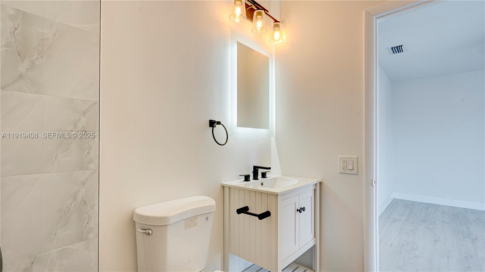 710 Southwest 114th Avenue, Unit C3 Sweetwater, FL 33174 - Photo 16 of 25 a bathroom with a sink a mirror a toilet and shower