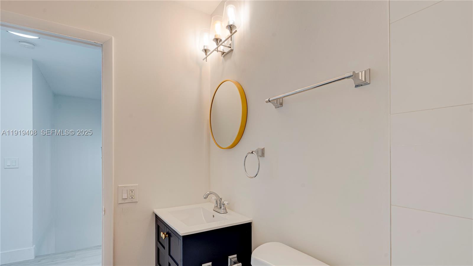 710 Southwest 114th Avenue, Unit C3 Sweetwater, FL 33174 - Photo 22 of 25 a bathroom with a sink and mirror with toilet