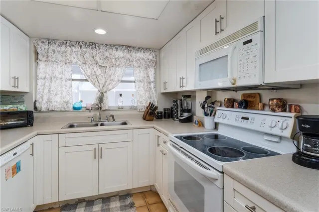 a kitchen with cabinets appliances a sink and a window