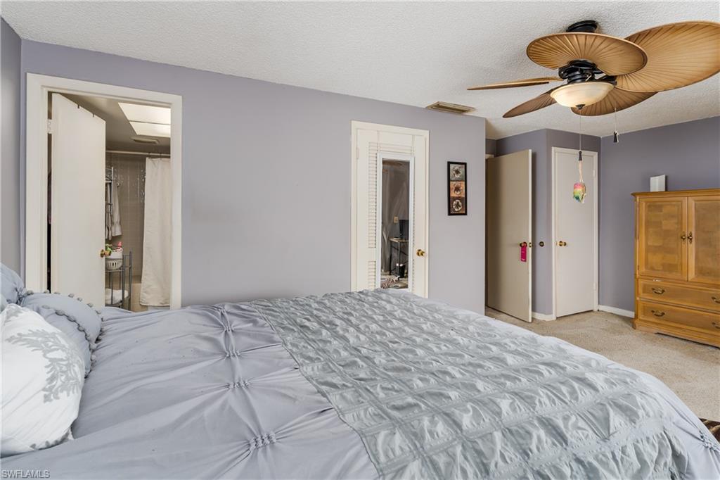 20 Watercolor Way Naples, FL 34113 - Photo 15 of 44 a bedroom with a bed and a chandelier