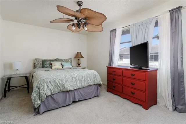 a bedroom with a bed and a flat tv screen on dresser