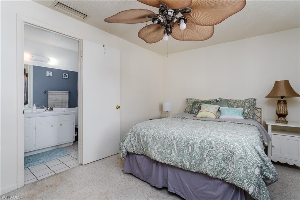 20 Watercolor Way Naples, FL 34113 - Photo 18 of 44 a bedroom with a bed and chandelier