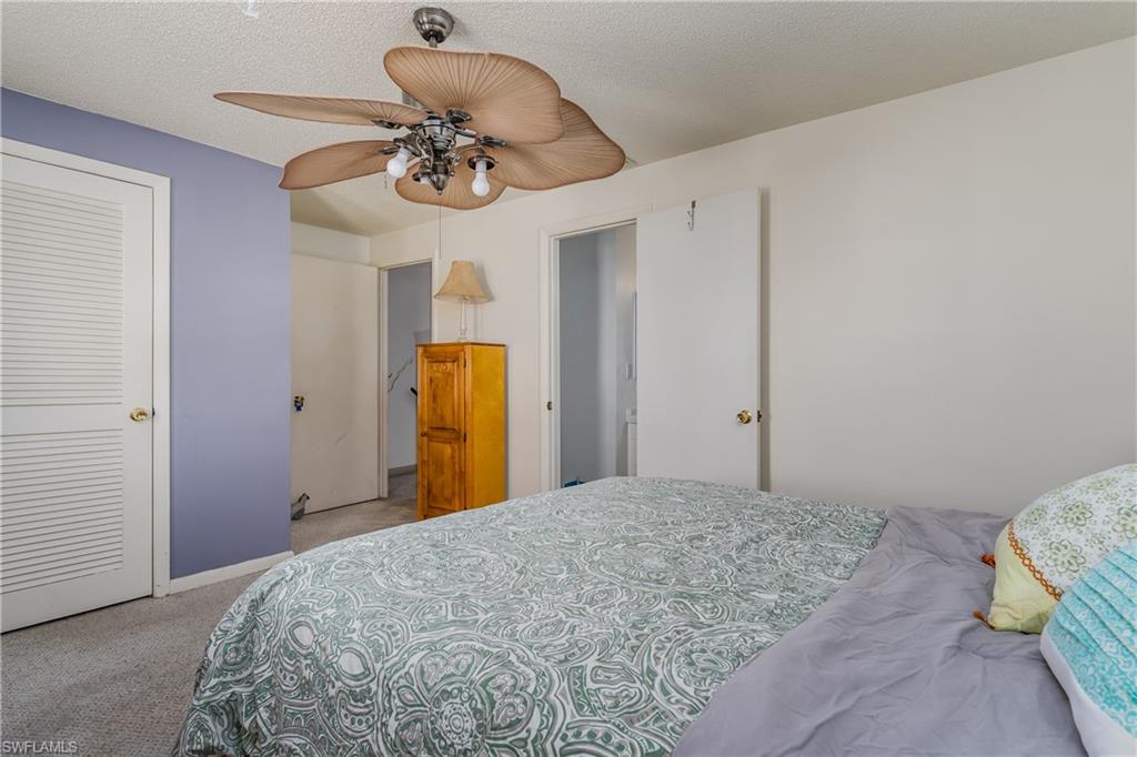 20 Watercolor Way Naples, FL 34113 - Photo 19 of 44 a bedroom with a bed and a chandelier