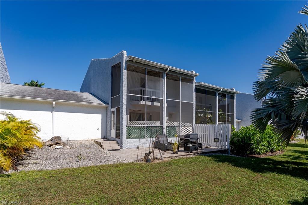 20 Watercolor Way Naples, FL 34113 - Photo 27 of 44 a backyard of a house with yard table and chairs