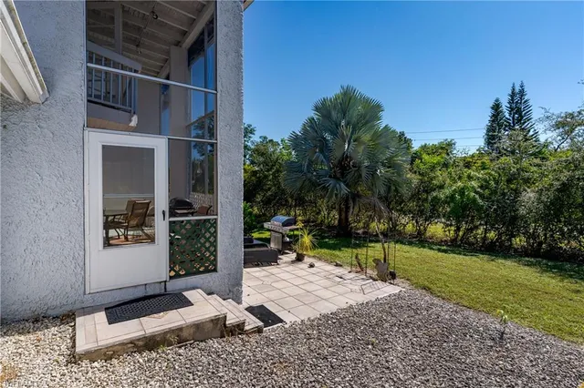 a view of a backyard with sitting area and tree