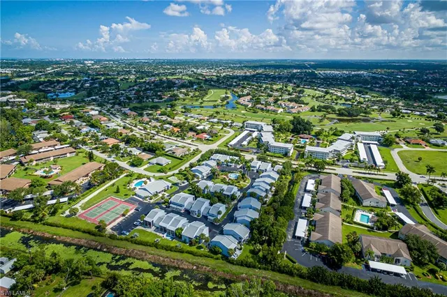 an aerial view of residential houses with outdoor space and trees