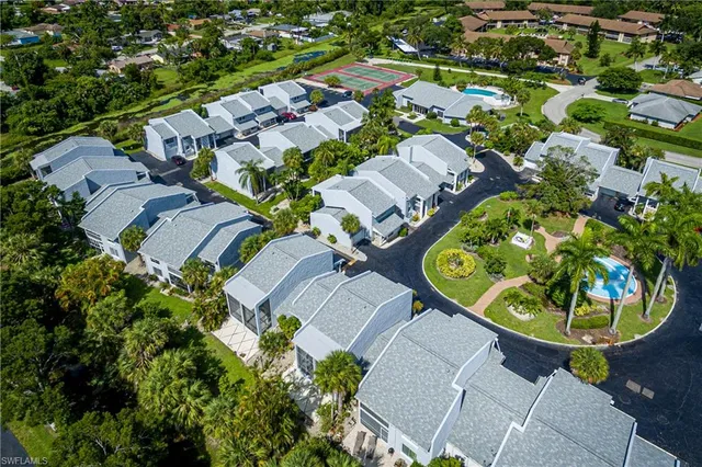 an aerial view of residential houses with outdoor space and parking