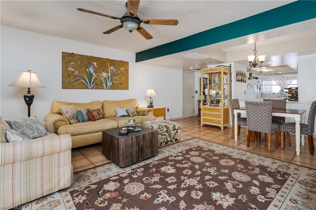 20 Watercolor Way Naples, FL 34113 - Photo 7 of 44 a living room with furniture a rug and a chandelier