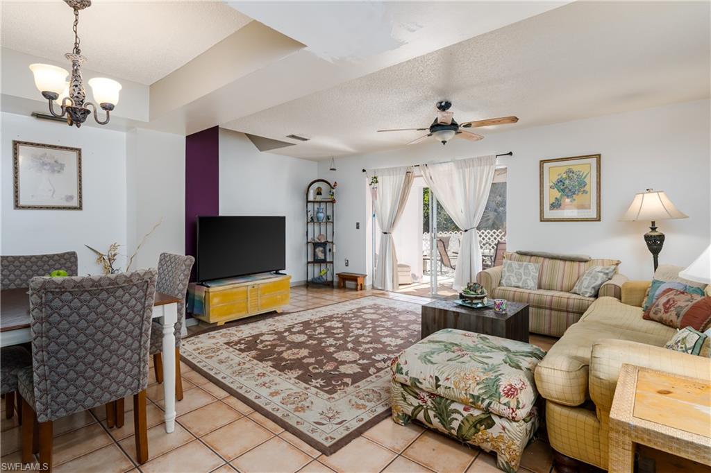 20 Watercolor Way Naples, FL 34113 - Photo 9 of 44 a living room with furniture a chandelier and a flat screen tv