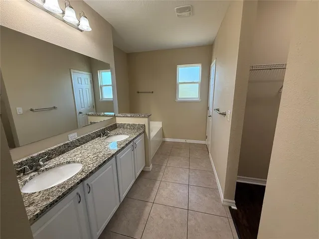 a bathroom with a granite countertop sink a toilet and a mirror