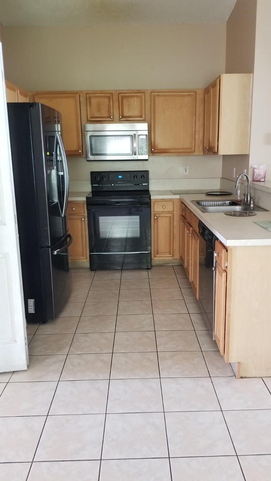 4629 Southwest 12th Street Deerfield Beach, FL 33442 - Photo 20 of 68 a kitchen with a sink a stove and a refrigerator