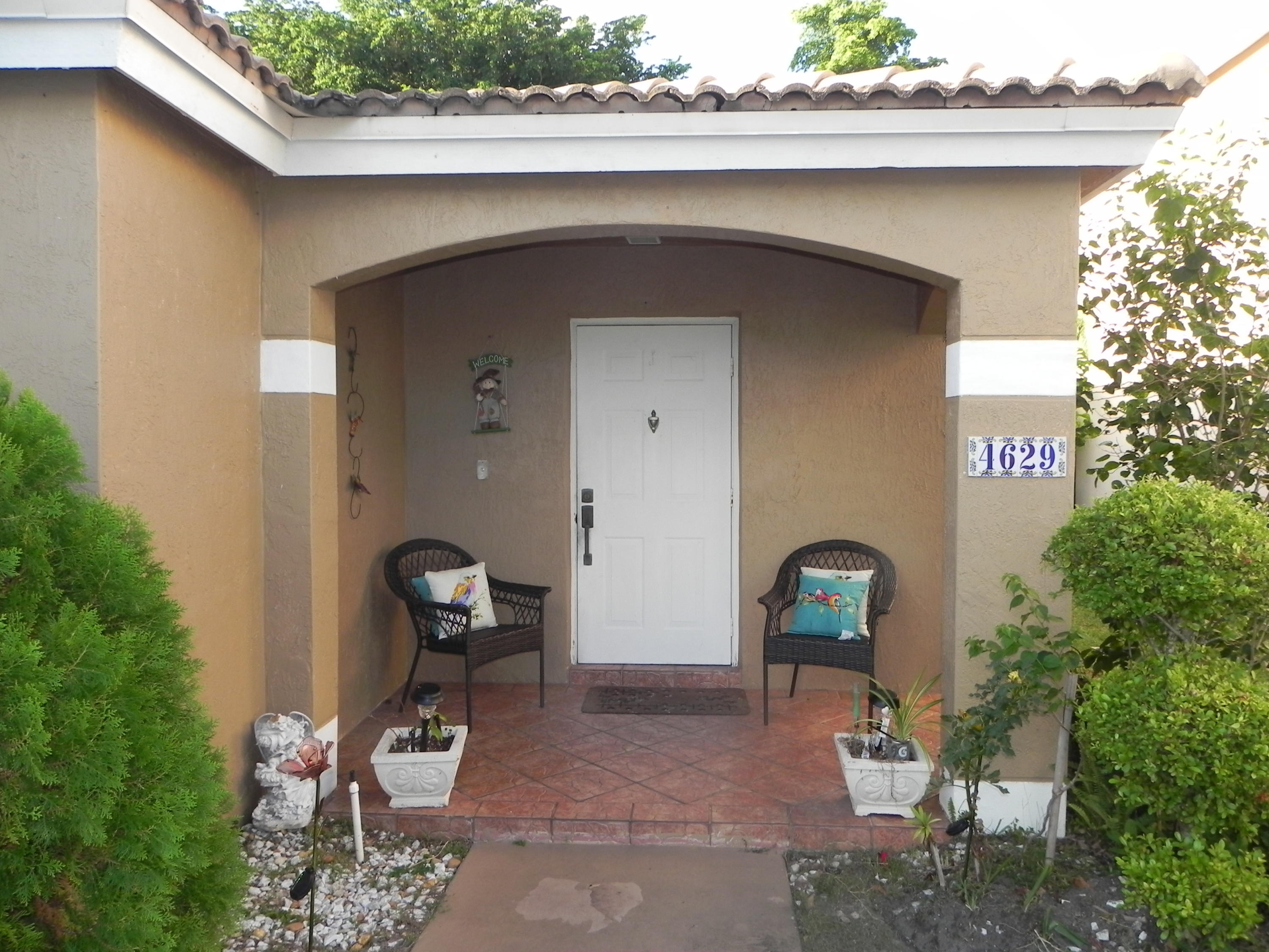 4629 Southwest 12th Street Deerfield Beach, FL 33442 - Photo 2 of 68 a front view of a house with outdoor seating