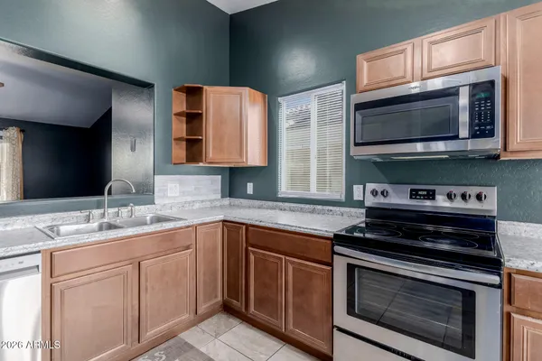 a kitchen with stainless steel appliances a stove microwave and sink