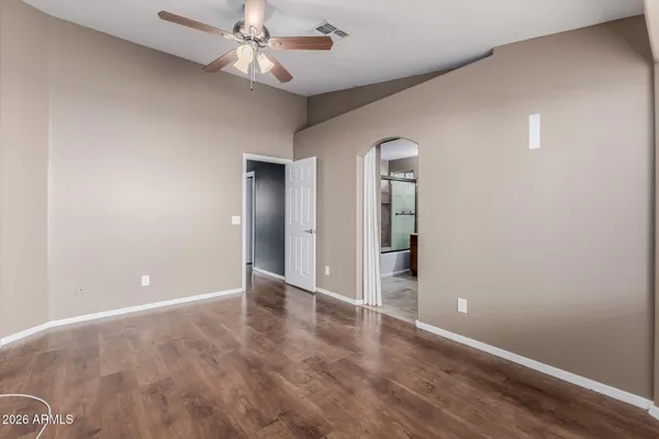 wooden floor in an empty room with a chandelier fan