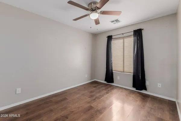 an empty room with closet and a ceiling fan