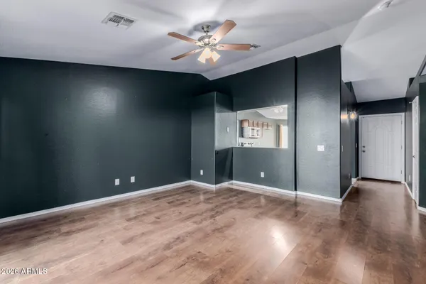 a view of an empty room with a ceiling fan and window