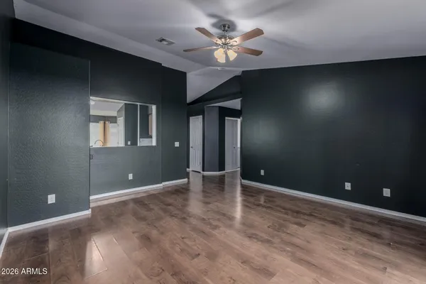a view of an empty room with chandelier fan