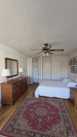 a large bedroom with a bed and wooden floor