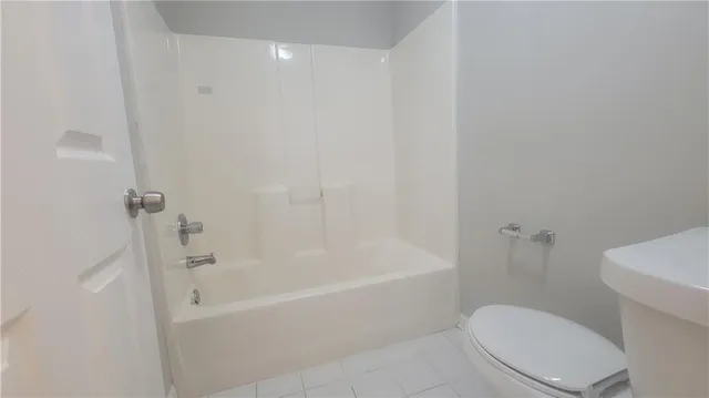 a white toilet sitting next to a bath tub