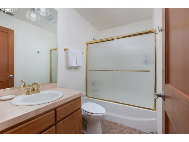 a bathroom with a sink toilet a mirror and shower