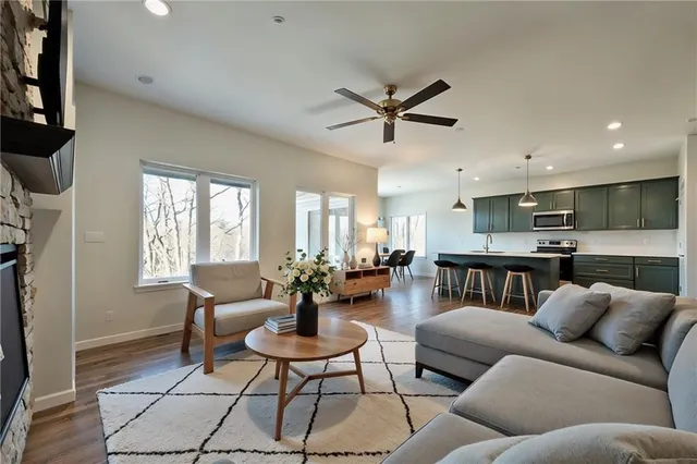 a living room with furniture kitchen view and a window