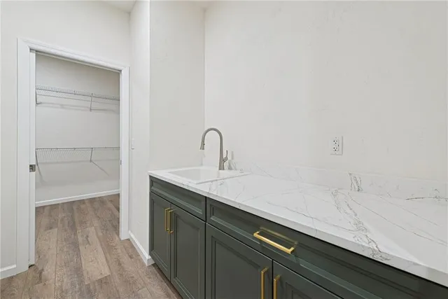 a view of a hallway with wooden floor and a bathroom