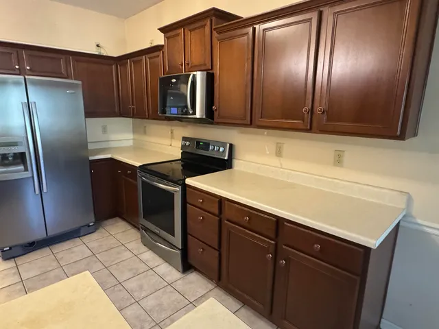 a kitchen with stainless steel appliances granite countertop a refrigerator and a sink