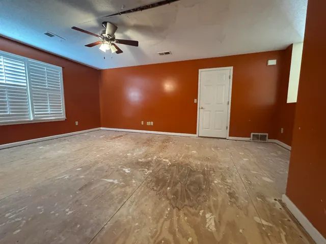 a view of an empty room with a chandelier fan