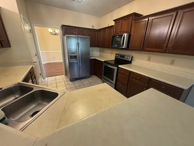 a kitchen with stainless steel appliances a sink and a refrigerator