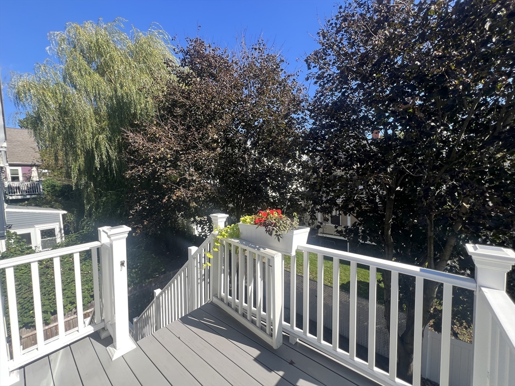 52 Victoria Street, Unit B Somerville, MA 02144 - Photo 2 of 15 a balcony with wooden floor and fence