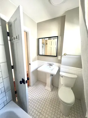 a bathroom with a toilet sink and mirror