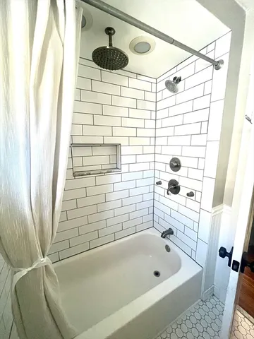 a bathroom with a bathtub and shower