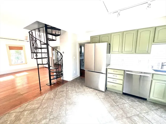 a kitchen with granite countertop a refrigerator and a stove top oven