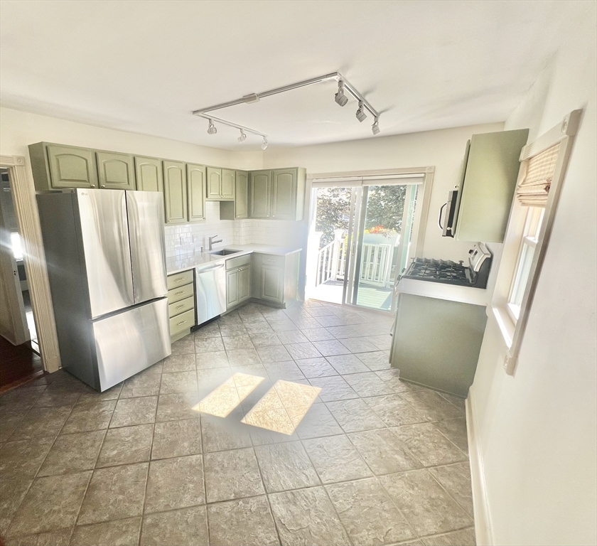 52 Victoria Street, Unit B Somerville, MA 02144 - Photo 9 of 15 a kitchen with stainless steel appliances granite countertop a refrigerator and a sink