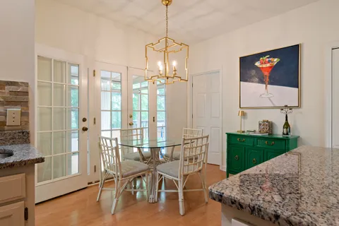 a kitchen with stainless steel appliances granite countertop a stove top oven a sink with dining table and chairs