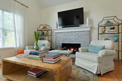 a living room with furniture a fireplace and a flat screen tv