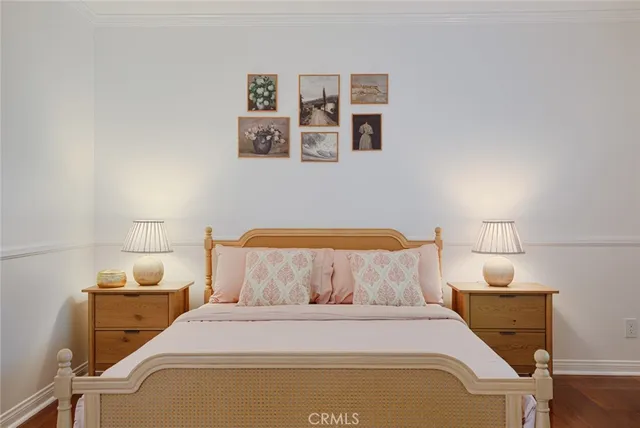 a bedroom with a bed and painting on the wall