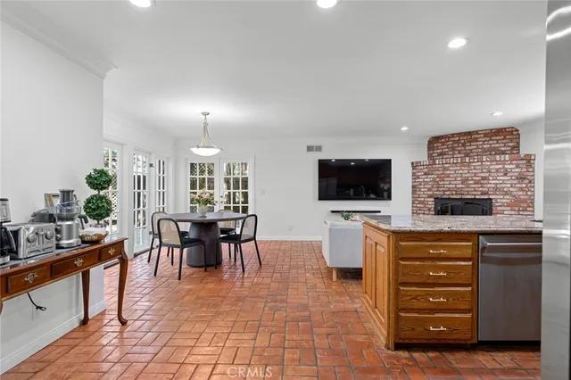 a living room with furniture a flat screen tv and kitchen view
