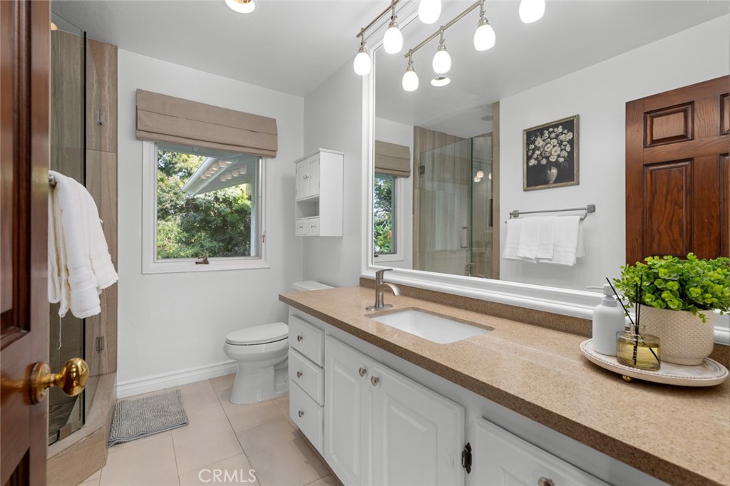 16842 Harkness Circle Huntington Beach, CA 92649 - Photo 33 of 43 a spacious bathroom with a granite countertop sink a large mirror and a shower