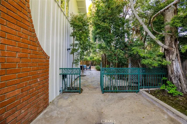 a view of a pathway of a house with wooden fence