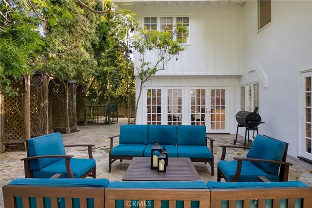 a view of a patio with couches table and chairs and potted plants