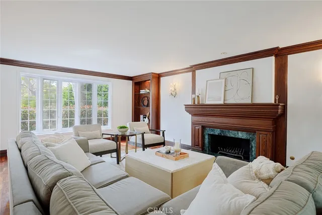 a living room with furniture a fireplace and a large window