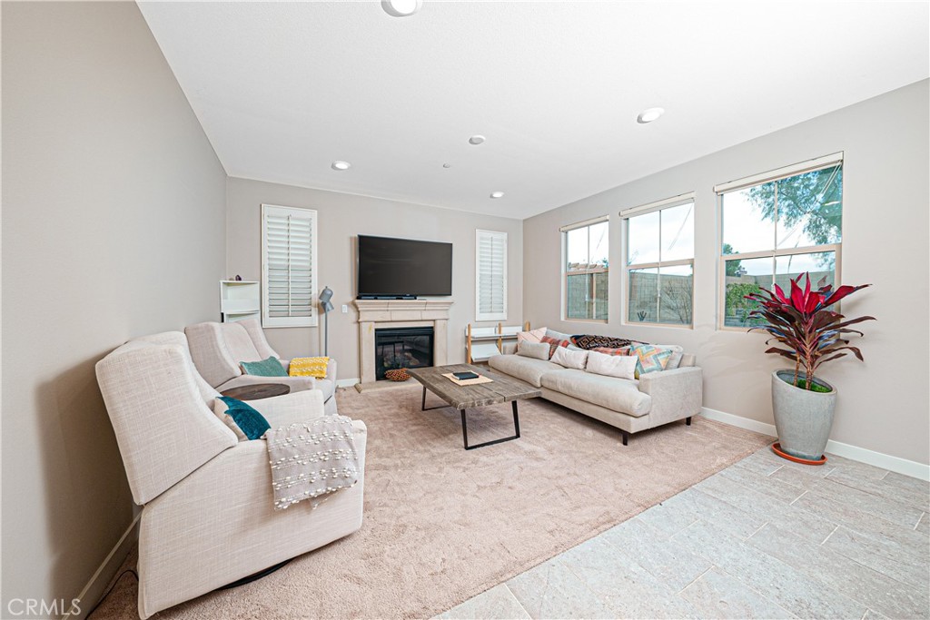 106 Tinker Irvine, CA 92618 - Photo 20 of 36 a living room with furniture a flat screen tv and a potted plant