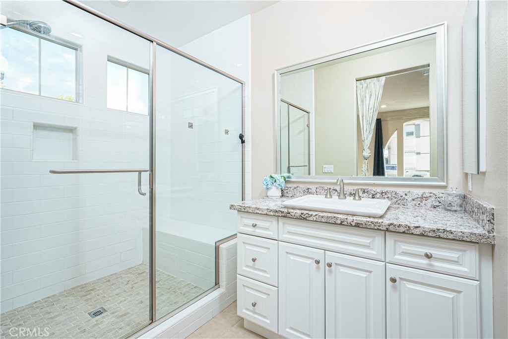 106 Tinker Irvine, CA 92618 - Photo 25 of 36 a bathroom with a granite countertop sink mirror and a shower