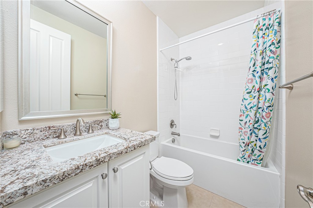 106 Tinker Irvine, CA 92618 - Photo 32 of 36 a bathroom with a granite countertop sink toilet a mirror a vanity and bathtub