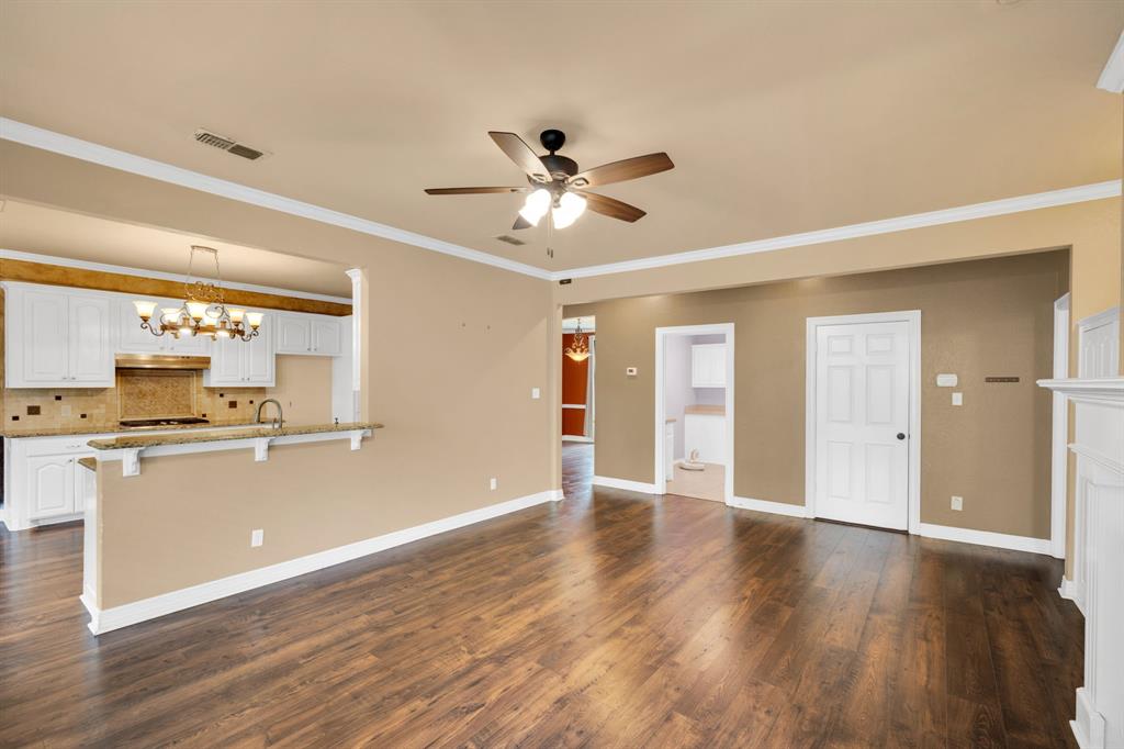 1907 Timber Ridge Court Cedar Hill, TX 75104 - Photo 10 of 30 Open-concept living space featuring wood-finish flooring, a ceiling fan with integrated lighting, and crown molding